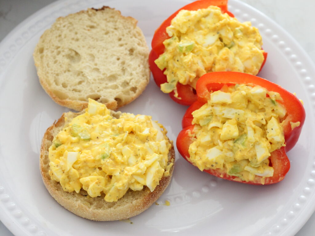 Egg salad on an English muffin and a red bell pepper