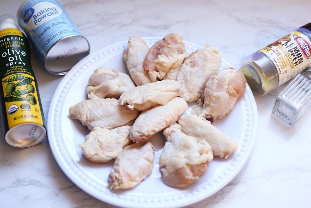 chicken wings on a white plate surrounded by ingredients 