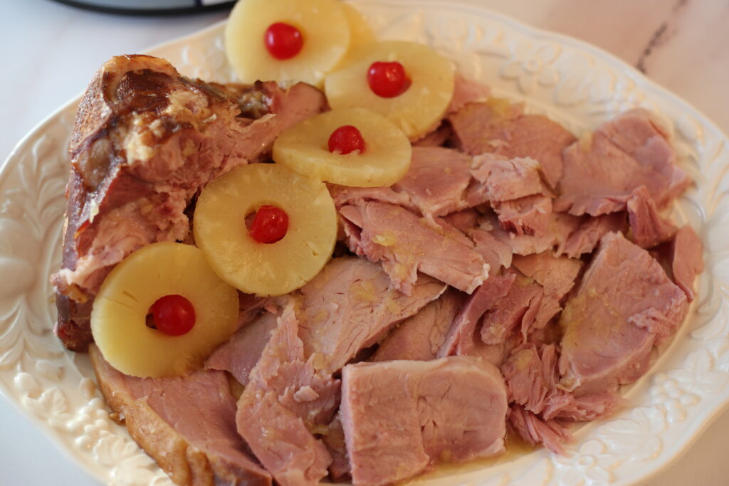 Slice ham on a platter with pineapple slices and cherries on top