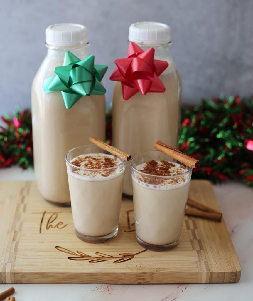 Puerto Rican eggnog in a glass milk jug with Christmas bows.