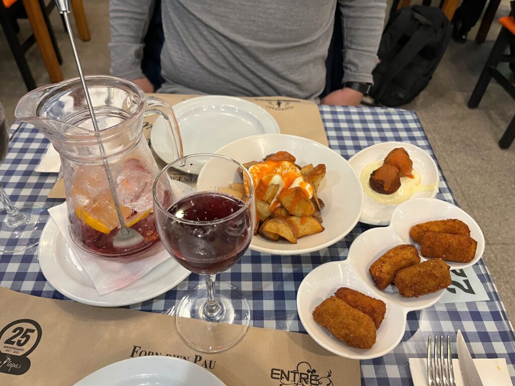 Appetizers on small white plates on a checkered table cloth. 