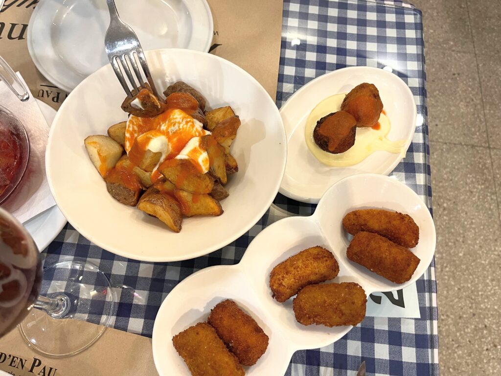 Fried Tapas on white plates with a fork