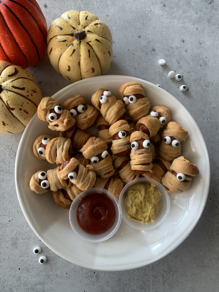 Weenies wrapped with Dough to look at mummies with candy eyes.